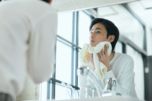花粉対策で洗顔する男性