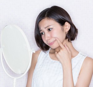 寝不足で肌荒れの女性