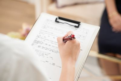 アンケート調査に回答する女性の手元