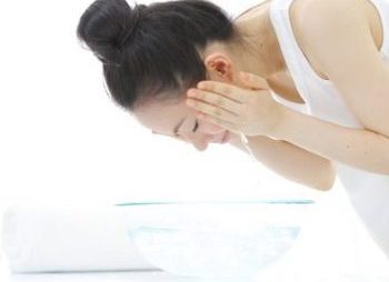 ぬるま湯で洗顔を落とす女性