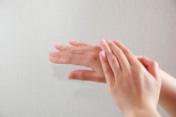 スマホによる手荒れをケアする女性