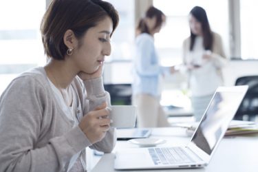 むくみを招きやすい座ったままのデスクワークをする女性