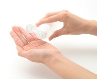 手で化粧水をつける50代の女性