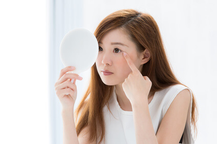 目の下のたるみの解消法を考える女性