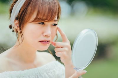 目元の小じわを気にする女性