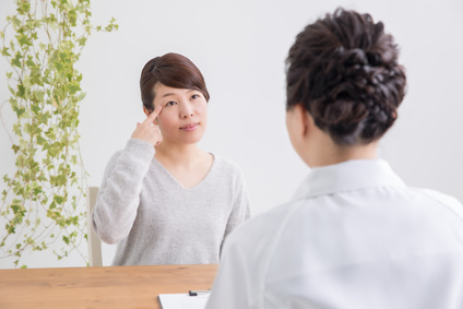まつ毛貧毛症で病院の医師のアドバイスを受ける女性