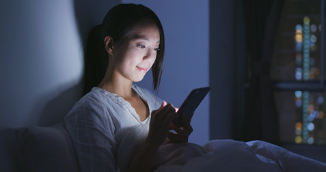 夜遅くまでスマホを見る女性