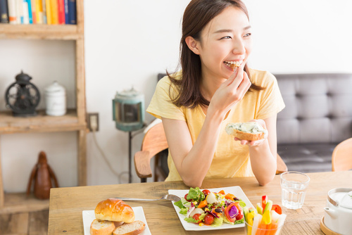 笑顔とともに毎日のエイジングケアでほうれい線予防する女性