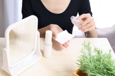 コットンで化粧水パックをしようとする女性の手