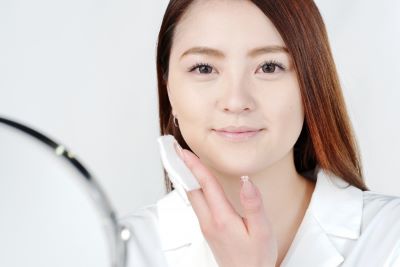おすすめできないコットンで化粧水をパッティングする方法をする女性