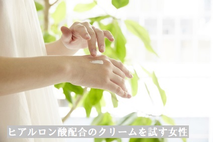 保湿のためにヒアルロン酸が配合されたクリームを試す女性の手